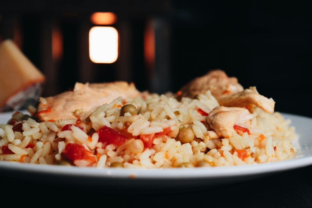 Close-up of a delicious chicken and rice meal with vegetables on a plate.